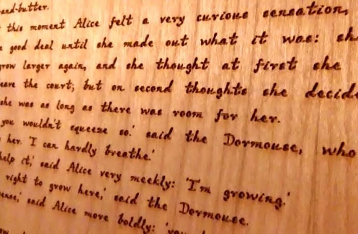El texto grabado en las páginas de madera fue diseñado para parecerse a la letra de Lewis Carroll.