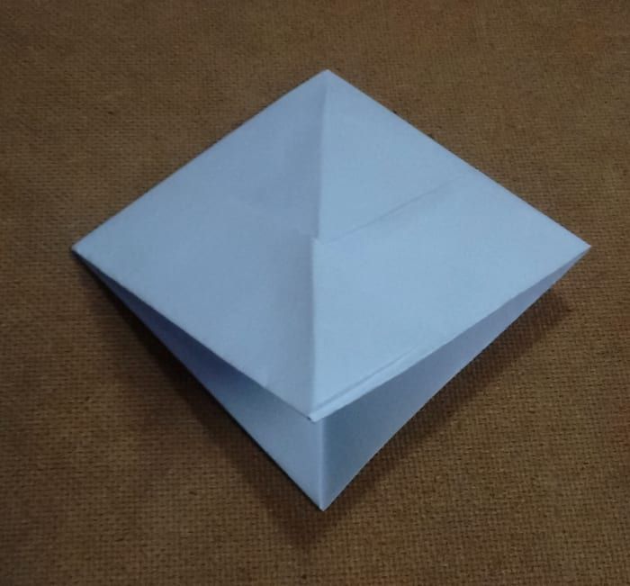 Esto da como resultado la formación de una estructura de papel de forma cuadrada con dos esquinas inferiores.
