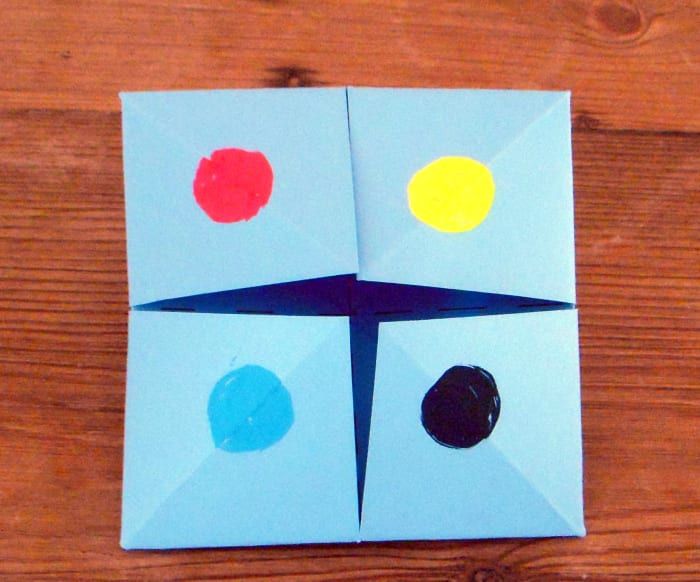 Направете различна цветна точка на всеки квадратен капак. (Това е предната страна на сгънатата хартия.)