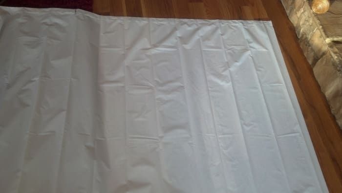 Mide y corta una cortina de ducha para que se ajuste al mástil de la balsa.