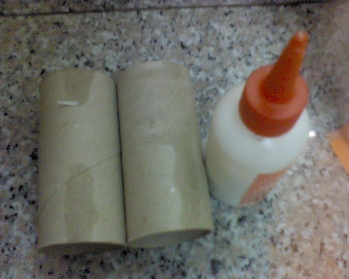 Prepare rollos de papel higiénico y una botella de pegamento blanco.