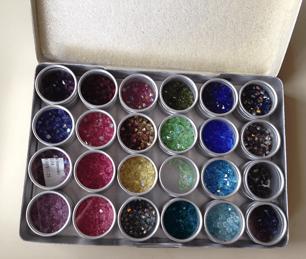 Photo de boîtes de rangement de perles remplies de cristaux Swarovski bicône