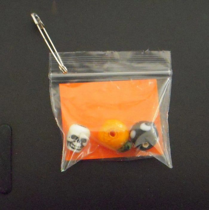 To je preprost SWAP, ki uporablja razsute tematske kroglice za noč čarovnic: lobanjo, bučo in črno mačko. Oranžna karta se glasi