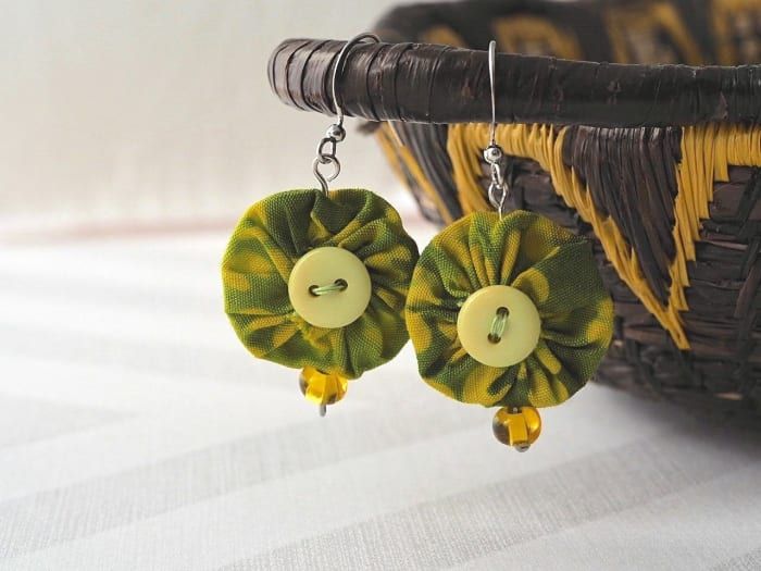 Erstellen Sie mit diesem einfachen Tutorial Ihr eigenes Paar dieser einzigartigen Jo-Jo-Ohrringe mit ein paar Stoffresten, Knöpfen, Perlen und Schmuckzubehör.