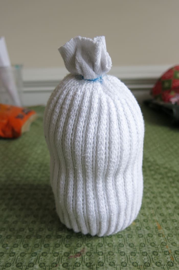 Llene el cuerpo de su muñeco de nieve de calcetín con relleno de fibra o bolas de algodón antes de cerrarlo con una banda de goma o hilo.