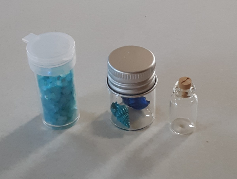   Vous aurez besoin de paillettes hexagones aqua ou bleues, de coquillages peints et d'une petite bouteille pour créer cet engin océanique magique.
