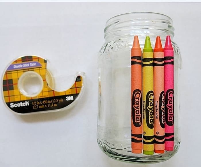 Puede usar cinta adhesiva doble para adherir crayones a los frascos.