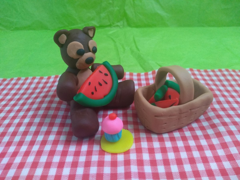   L'ours en peluche apprécie une belle grosse pastèque et un délicieux petit gâteau rose givré !