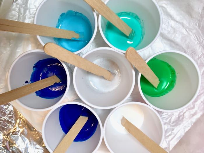 Plastične skodelice, napolnjene s tekočino za nalivanje in barvo.