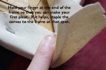 Ich lege meinen Finger an den Rand des Rahmens, um die Leinwand zu halten, während ich eine Falte mache.