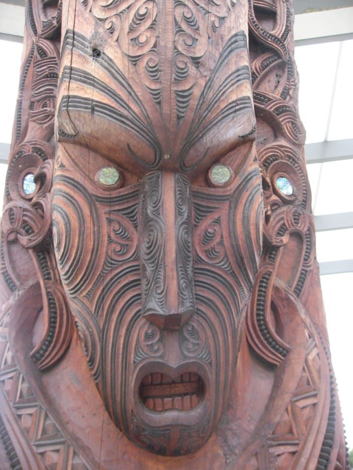 Gesichtsdetail vom Maori-Totempfahl am Rotorua Maori Cultural Ceter. Beachten Sie die einfachen Gesichtszüge mit aufwändigen Gesichtslinien, um die Maroir-Tätowierungen nachzuahmen.