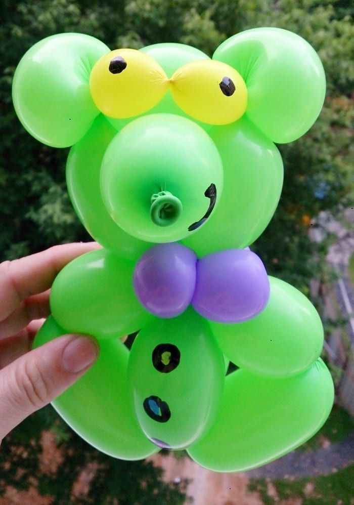 Die Schaffung eines grünen Teddybären mit einer lila Fliege ist eine unbeschwerte Art, Luftballons zu verwenden.