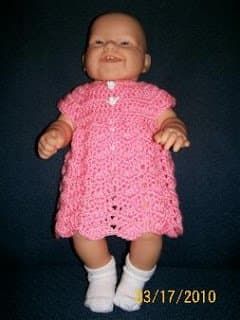 Vestido de bebé de chevron ondulado en una muñeca.
