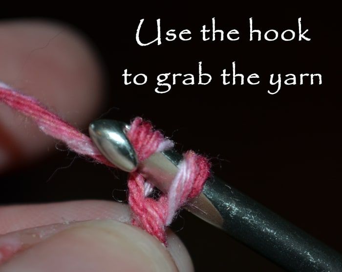 Usa el gancho para agarrar el hilo y pasarlo por el lazo que ya está en el gancho.
