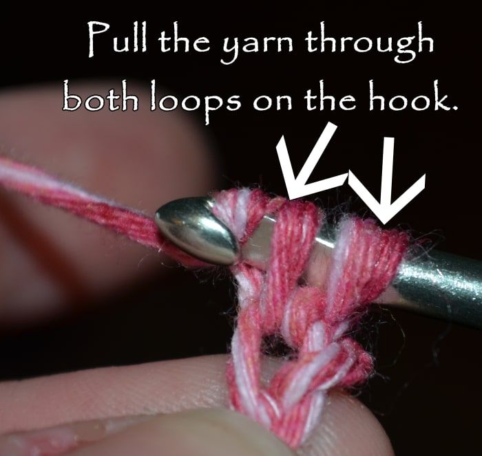 Teje y pasa el hilo a través de ambos bucles que ya están en el gancho.