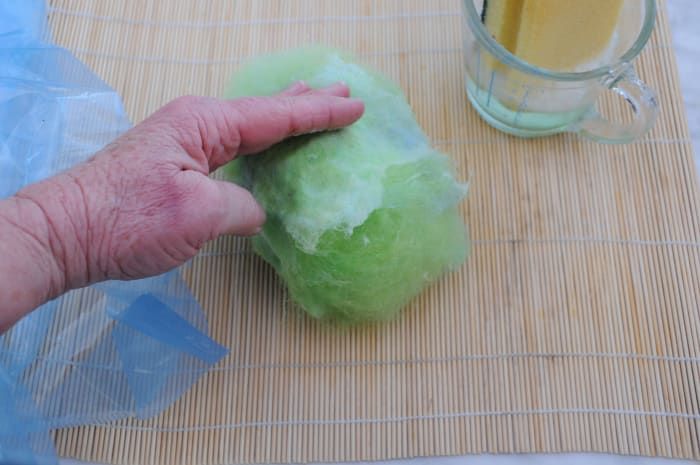 Humedezca las fibras suavemente con agua caliente y jabón y luego presiónelas contra la bola.