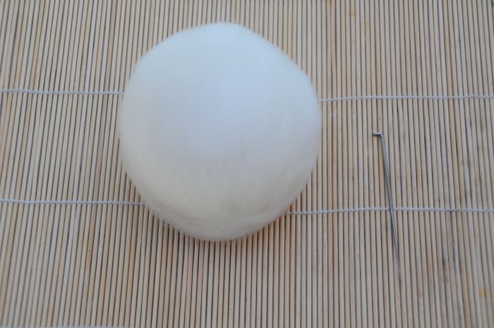 Der Ball ist mit weißem Merinowoll-Roving bedeckt