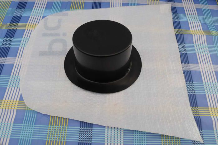 Schwarzer Kunststoff liefert Hut und Schablone, die aus einer dicken Plastikfolie geschnitten sind