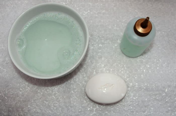 Schüssel mit warmem Seifenwasser, Quetschflasche und einem Stück Taubenseife