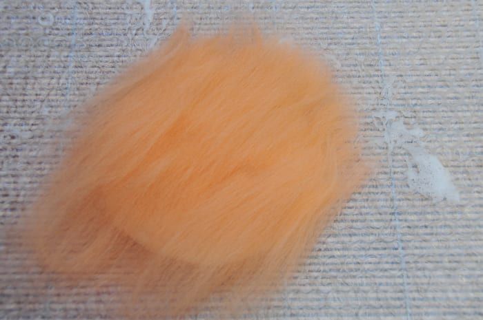 Decken Sie die weiße Schicht mit einer dünnen Schicht orangefarbener Fasern ab.