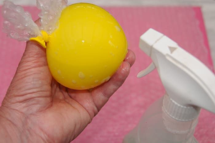 Rocíe agua caliente con jabón sobre el globo de fiesta inflado