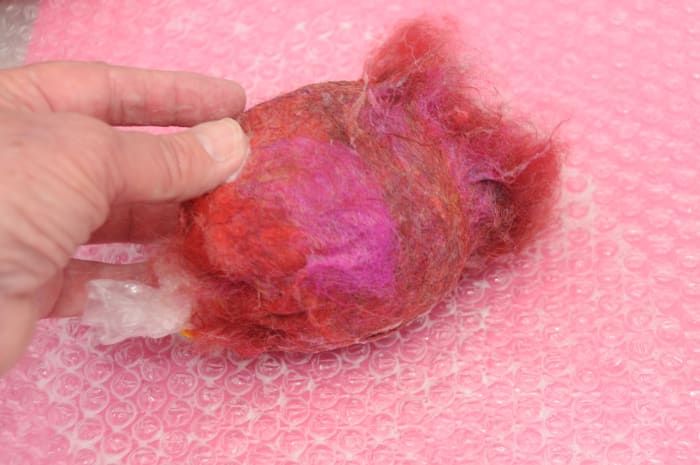 Alise las fibras haciendo rodar el globo sobre una superficie húmeda de plástico de burbujas.