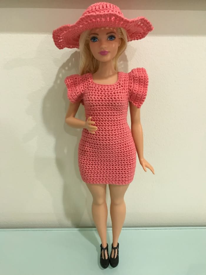 Sombrero de Barbie con curvas y vestido ajustado con mangas onduladas