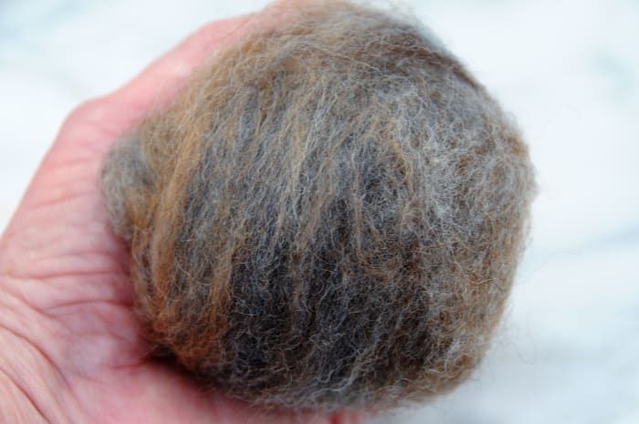 Comprima los trozos de lana en una bola apretada del tamaño de una mano abierta.