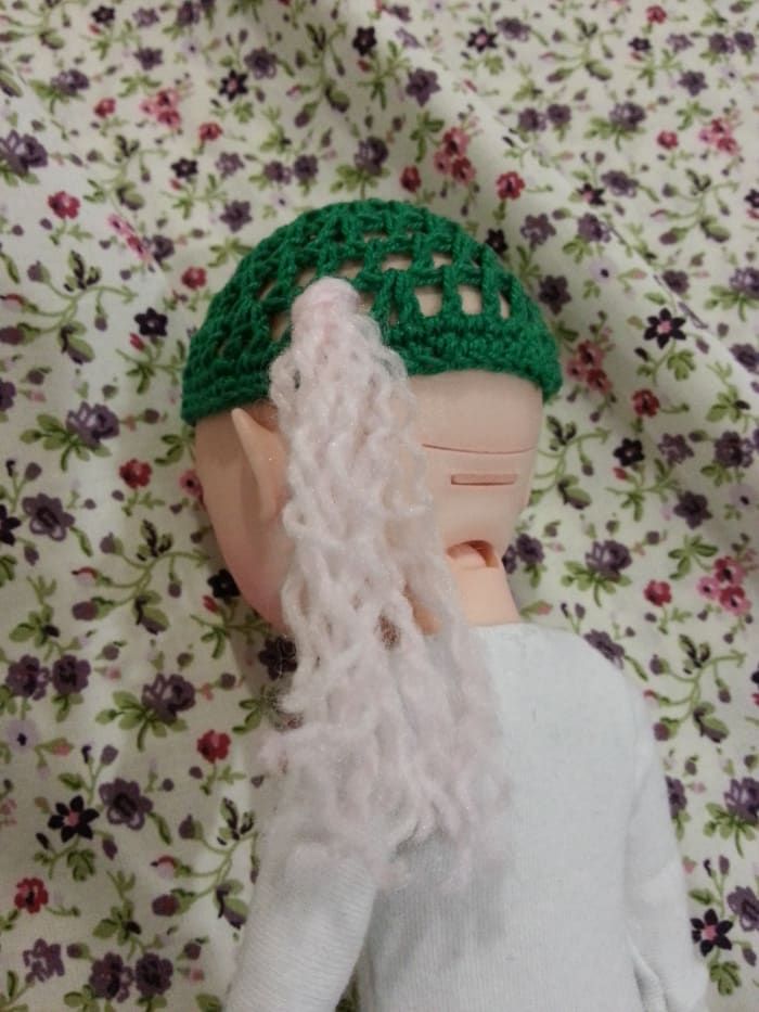 Un bouquet de fil attaché au bonnet de la perruque.