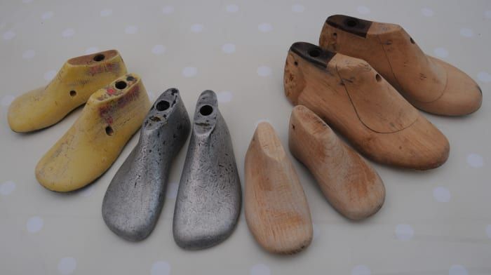 Un grupo de hormas de zapatos de metal y madera de tamaño infantil.