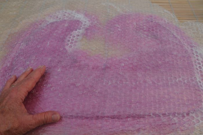 Reiben Sie die Oberfläche der Luftpolsterfolie, bis die darunter liegenden Fasern geglättet sind.