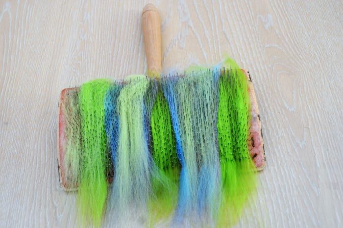 Agregue diferentes colores de lana a los dientes de las cardadoras de mano.