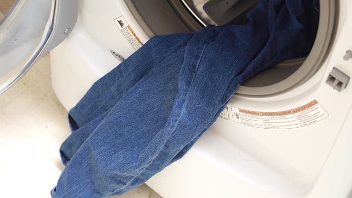 Werfen Sie Ihre Jeans in die Wäsche, um sie auf das Zuschneiden vorzubereiten.