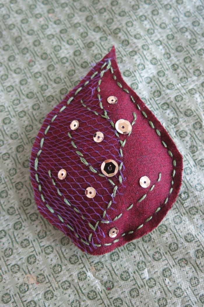 Füllen und dekorieren Sie Ihr Schrottblatt mit Perlen, Knöpfen oder Pailletten.