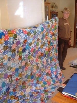 Margaret (student) visar den sexkantiga täcken som hon fyllt med från de många hexagonerna som hennes mamma tillverkade av skrottyger från familjen.